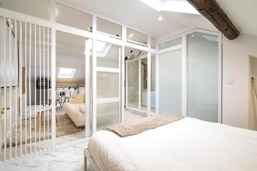 a bedroom with a bed and a living room at Suite Balnéo hydromassage et rétroprojecteur in Reims