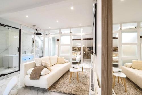 ein weißes Wohnzimmer mit einem Sofa und einem Tisch in der Unterkunft Oasis Chic - Spa privé & Cinéma in Reims