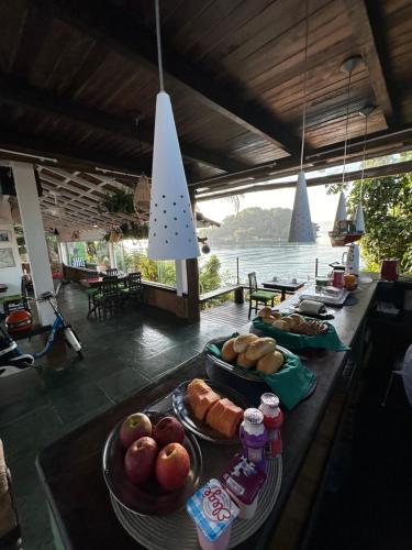 a table with plates of food and a view of the water at Cabana do Mar in Angra dos Reis