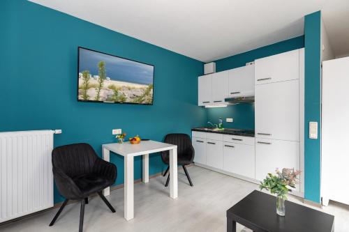 キュールングスボルンにあるHotel zur Traubeの青い壁のキッチン(テーブル、椅子付)
