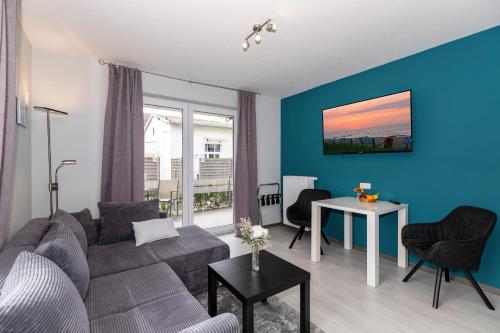 sala de estar con sofá gris y pared azul en Hotel zur Traube en Kühlungsborn