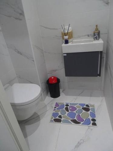 a bathroom with a toilet and a sink and a rug at La perle rare in Monastir