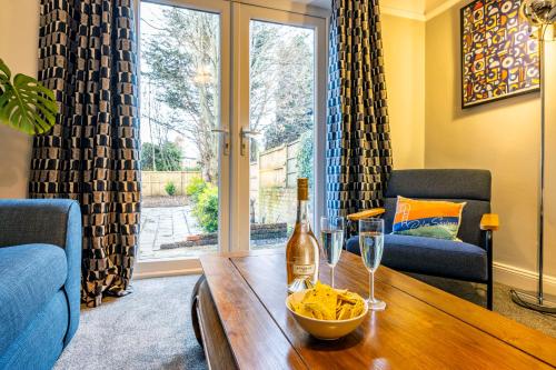 a bottle of wine and a bowl of chips on a wooden table at Lovely 4BDR home- Off street parking sleeps 7 in Nottingham