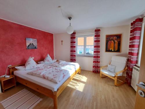 a bedroom with a bed and a chair in it at Ferienwohnung Sauer in Pfofeld