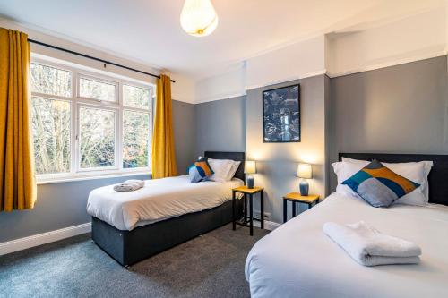 a bedroom with two beds and a window at Lovely 4BDR home- Off street parking sleeps 7 in Nottingham