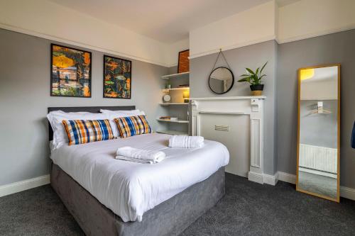 a bedroom with a large bed with towels on it at Lovely 4BDR home- Off street parking sleeps 7 in Nottingham