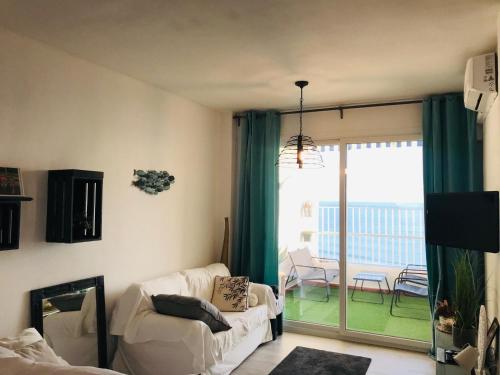 a living room with a couch and a sliding glass door at Apartamento Cloe con terraza y vistas al Mar in El Puerto de Santa María