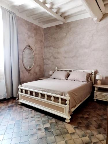 Un dormitorio con una cama y un espejo en la pared. en B&B La Sbàgera, en Stagno Lombardo
