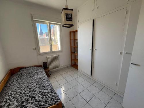 une petite pièce avec un lit et une fenêtre dans l'établissement Chambre entre plage et centre ville dans maison avec jardin, au Havre