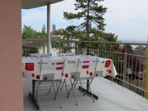 a table and chairs sitting on a balcony at Chez Carole (4 pièces) in Neuchâtel