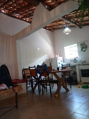 パウメイラスにあるHostel do Capãoのテーブルと椅子、キッチンが備わる客室です。
