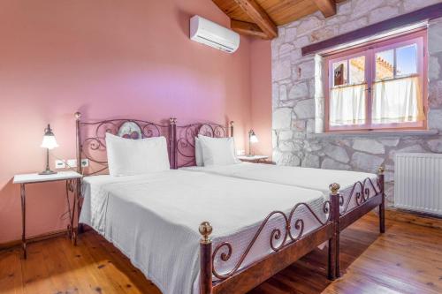 1 dormitorio con 1 cama grande y pared de piedra en Villa Ira, en Agios Leon
