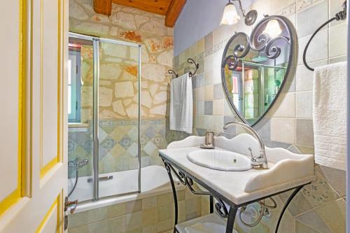 y baño con lavabo y espejo. en Villa Ira, en Agios Leon