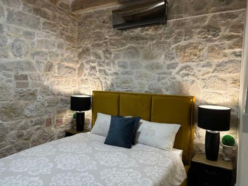 sypialnia z łóżkiem i kamienną ścianą w obiekcie Stone house Chiara Seaview w mieście Funtana