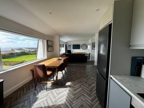a kitchen and dining room with a table and a window at 1 Seaview Portstewart in Portstewart