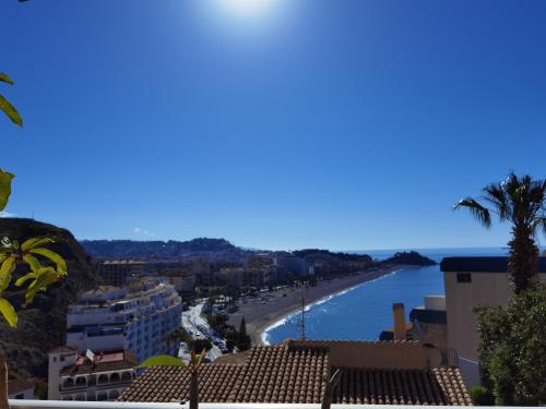 uitzicht op een strand met palmbomen en gebouwen bij Miramar 22 in Almuñécar