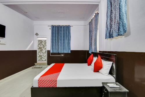 a bedroom with a bed with red pillows at OYO Flagship Hotel Golden Inn in Bhiwadi