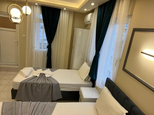 a hotel room with two beds and a window at Almir Otel in Erdemli