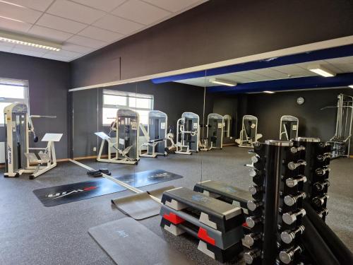 a gym with treadmills and machines in a room at Hotell Erikslund in Ängelholm