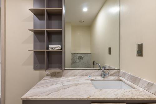a bathroom with a sink and a shower at Capital Emerald Line 1 bed by YourHost, Westlands Nairobi in Nairobi