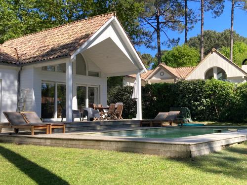 een huis met een zwembad in de tuin bij Villa DUNE in Biscarrosse