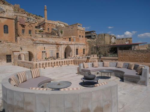 un patio con sedie e tavoli di fronte a un edificio di Mirsoum Han a Mardin