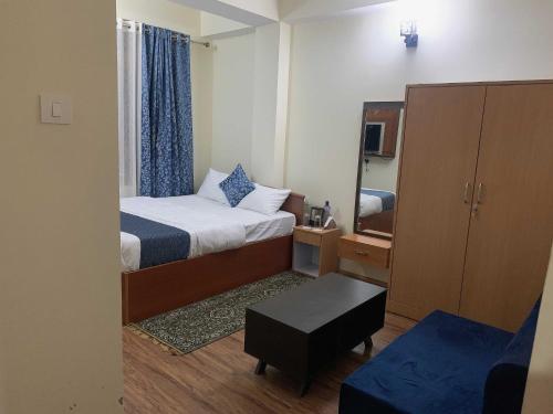 Habitación pequeña con cama y espejo. en OYO Home Urvi Griham en Gangtok
