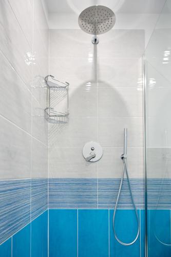 a bathroom with a shower with blue and white tiles at B&B Dreaming in Avola