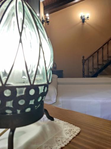 a glass lamp sitting on a table next to a bed at El cerro de cabañeros in Retuerta de Bullaque