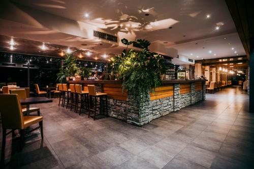 um restaurante com um bar com mesas e cadeiras em Hotel OSTREDOK em Demanovska Dolina
