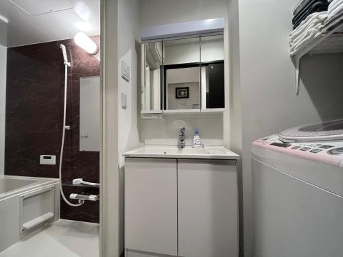 a small white bathroom with a sink and a shower at Relax House in Tokyo