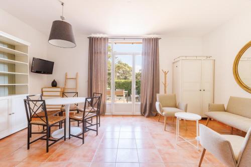 a living room with a table and chairs at Le Domaine de la mer - Appartements de plage dans un cadre enchanteur in Hyères