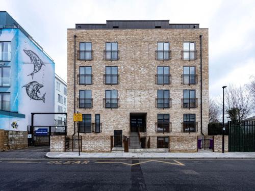 um edifício de tijolos ao lado de uma rua em Luxurious Apartments Hackney near Train Station em Londres