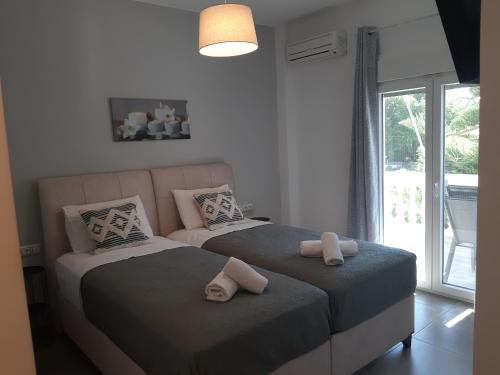 a bedroom with two beds with towels on them at Villa Pappas in Parga