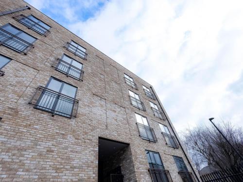 um edifício de tijolos com janelas do lado em Luxurious Apartments Hackney near Train Station em Londres