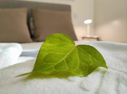 a green leaf sitting on top of a bed at Casa do Barbeiro - View of the River Minho in Melgaço
