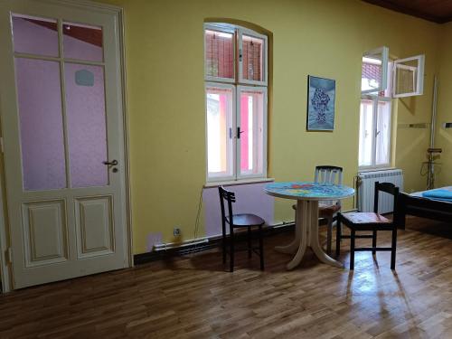 a room with a table and chairs and a door at Micro Maxi House in Bela Crkva