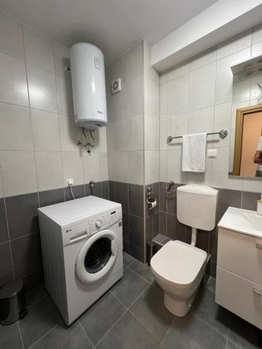 a bathroom with a washing machine and a toilet at New apartment near Split with garage in Solin
