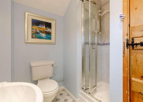 uma casa de banho branca com um WC e um chuveiro em Cottage at The Butchers Arms em Gloucester