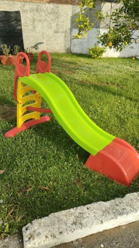 a green and red slide in the grass at Ndiscialamu Casa Vacanze in Palmi