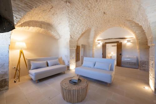 a living room with two couches and a table at Masseria Nicola Casavola in Martina Franca