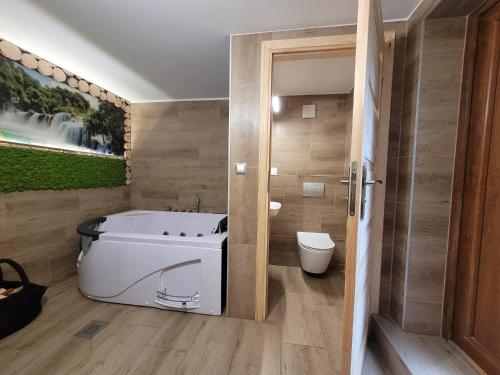 a bathroom with a bath tub and a toilet at Agroturystyka Oblica in Zawoja