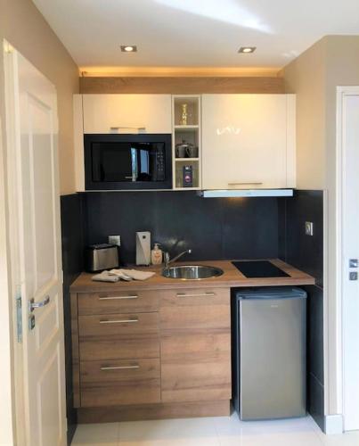 une cuisine avec un évier et un plan de travail dans l'établissement RDC 2 - Studio meublé centre-ville, au pied du pont Saint Pierre, à Montluçon