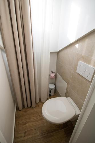 a white toilet in a bathroom with a window at Les Rebelles in Paris
