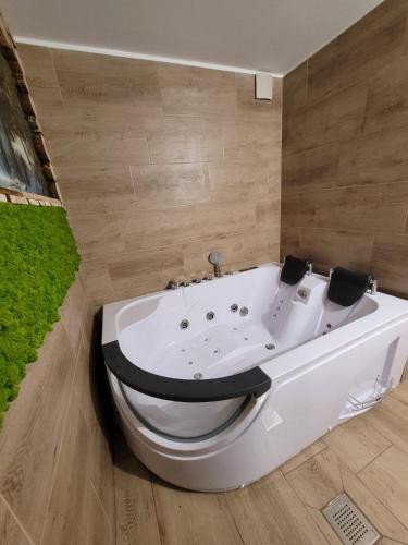 a bath tub in a bathroom with a green rug at Agroturystyka Oblica in Zawoja