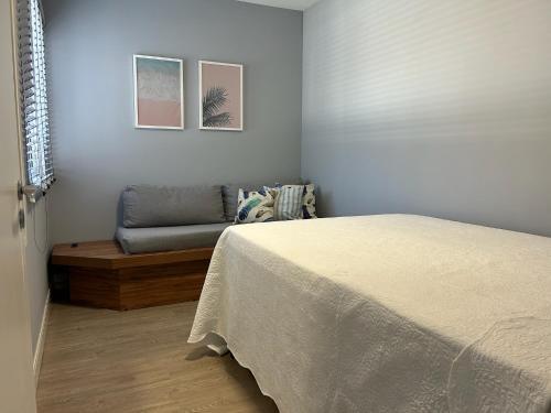 a bedroom with a bed and a couch at Apto 28A - Residencial Palladium Centro, Penha SC in Penha