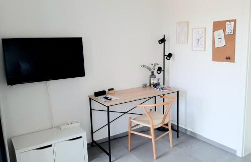 a desk with a chair and a television on a wall at Bude 23 - Ferienwohnung Aalen in Aalen