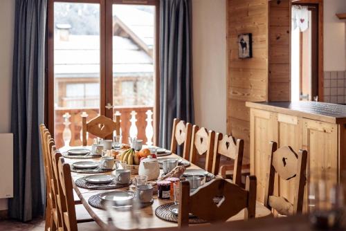 une table de salle à manger avec de la nourriture dessus dans l'établissement Madame Vacances Chalet L'Arclusaz, à Les Allues