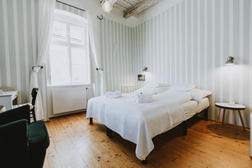 a bedroom with a large bed with white sheets and a window at Villa Mimi in Sopron