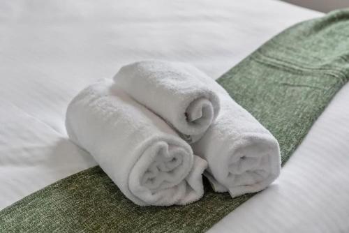 a pile of white towels on a green towel at Bay Bliss - Coastal Villa in Nelson Bay